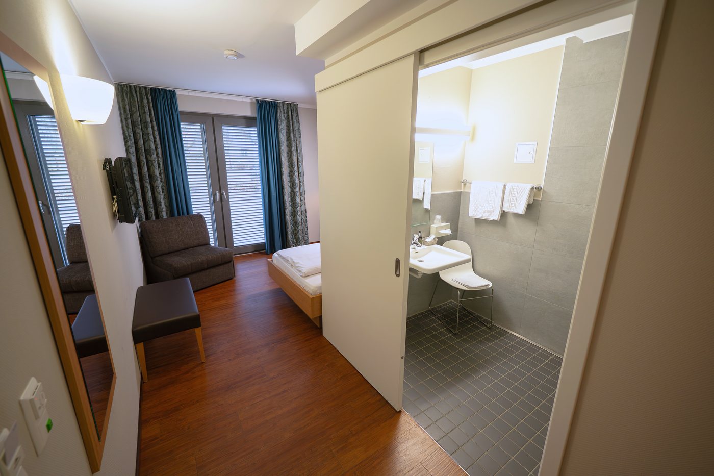 Wheelchair-accessible room with open bathroom area at Sebcity Hotel
